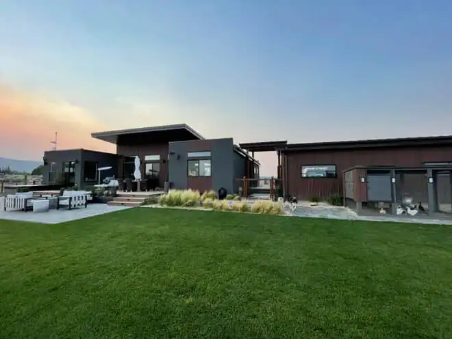 Alpine panelized home exterior with large garage and back deck.