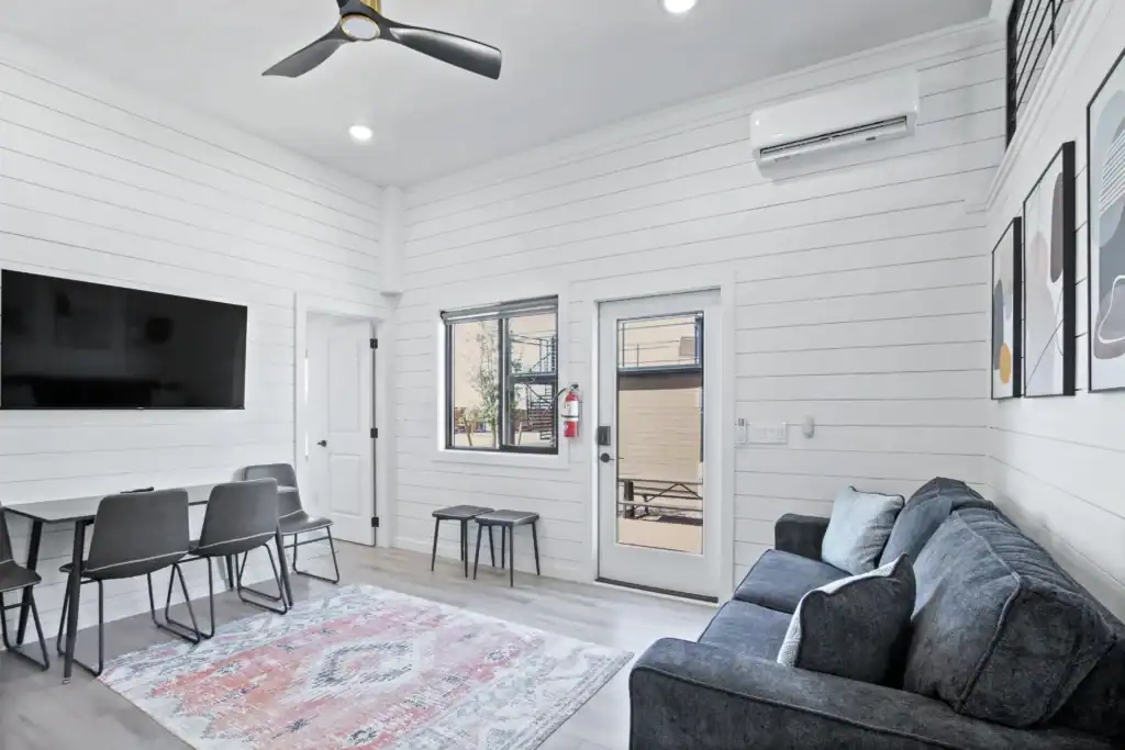 Bright, modern modular living room with white walls and gray furniture.