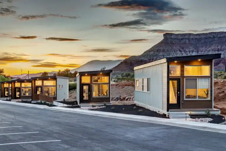 Contemporary modular homes with large windows at sunset.