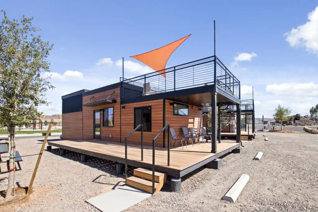 Contemporary modular tiny home with rooftop deck and outdoor seating area.
