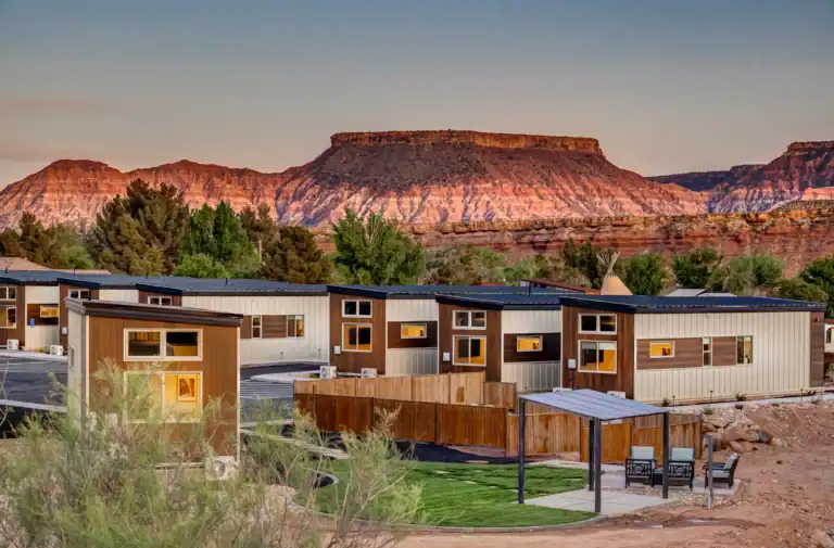 Modern modular homes with desert landscape and red rock formations.