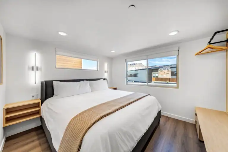 Bright, modern bedroom with large windows and minimalist decor.