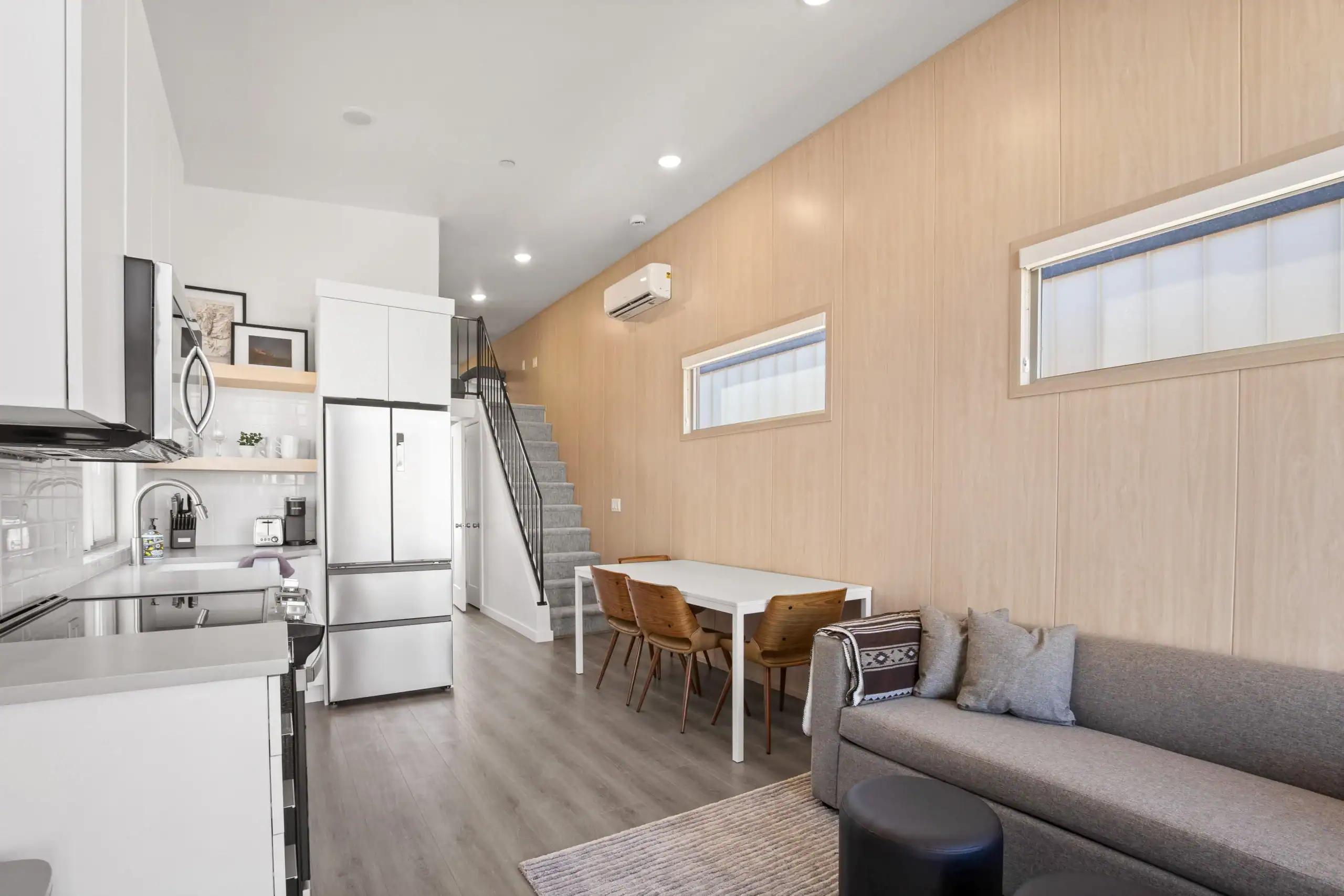 Contemporary Zip Kit home with large windows and outdoor seating in scenic mountain landscape.