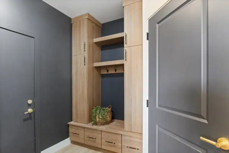 Wooden entryway storage with shelves and drawers in a modern home.