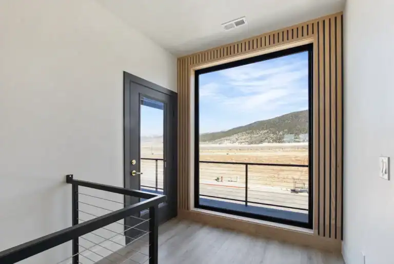 Bright interior with large window overlooking scenic landscape.