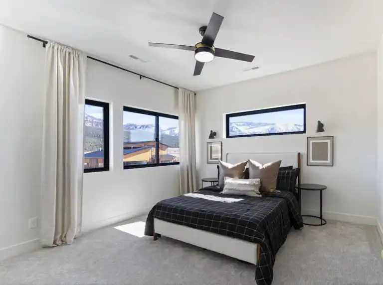 Bright modern bedroom with large windows and minimalist decor.