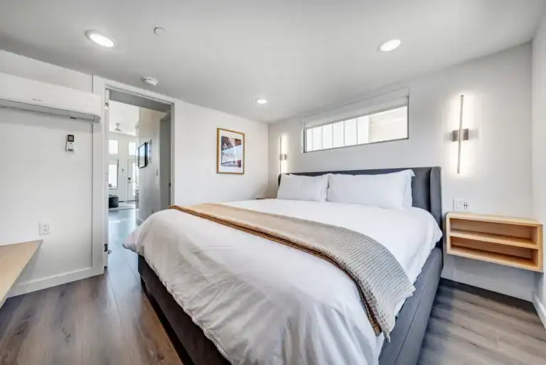 Bright modern bedroom with king-sized bed and minimalist decor.
