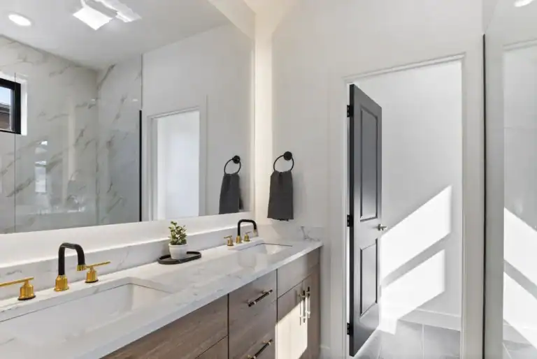 Bright modern bathroom with double vanity and black accents.
