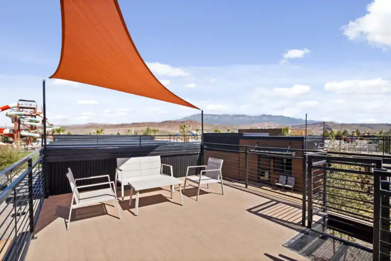 Contemporary modular home with wooden siding and outdoor seating area.