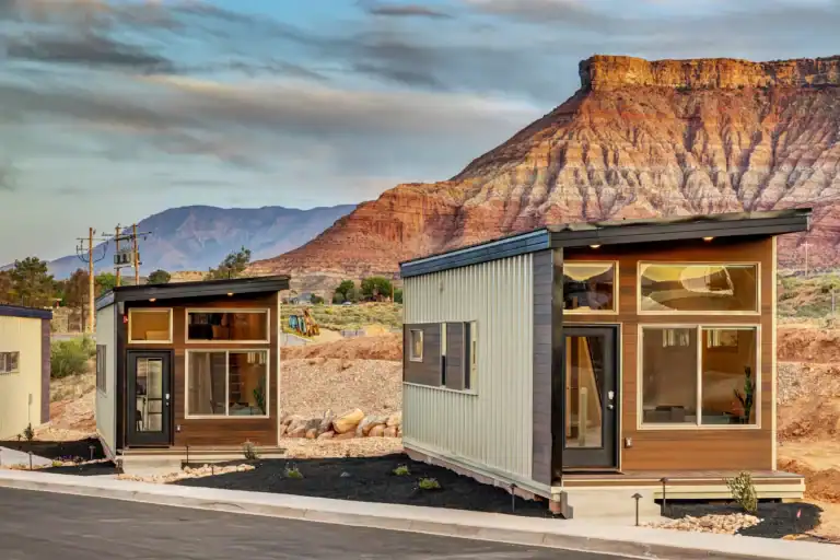 Modern modular homes with large windows and mountain backdrop.