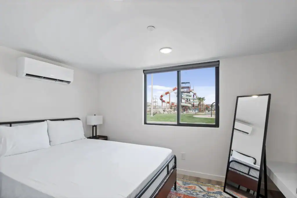 Bright bedroom with large window and minimalist decor.