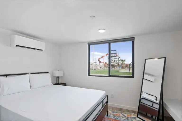 Bright bedroom with large window and minimalist decor.