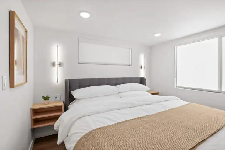 Bright modern bedroom with large window and minimalist decor.