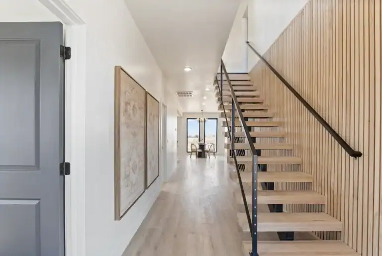Bright, modern interior with staircase and artwork in Zip Kit Home.