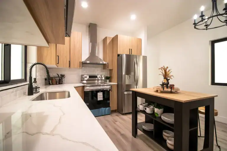 Modern kitchen with wooden cabinets, stainless steel appliances, and a central island.