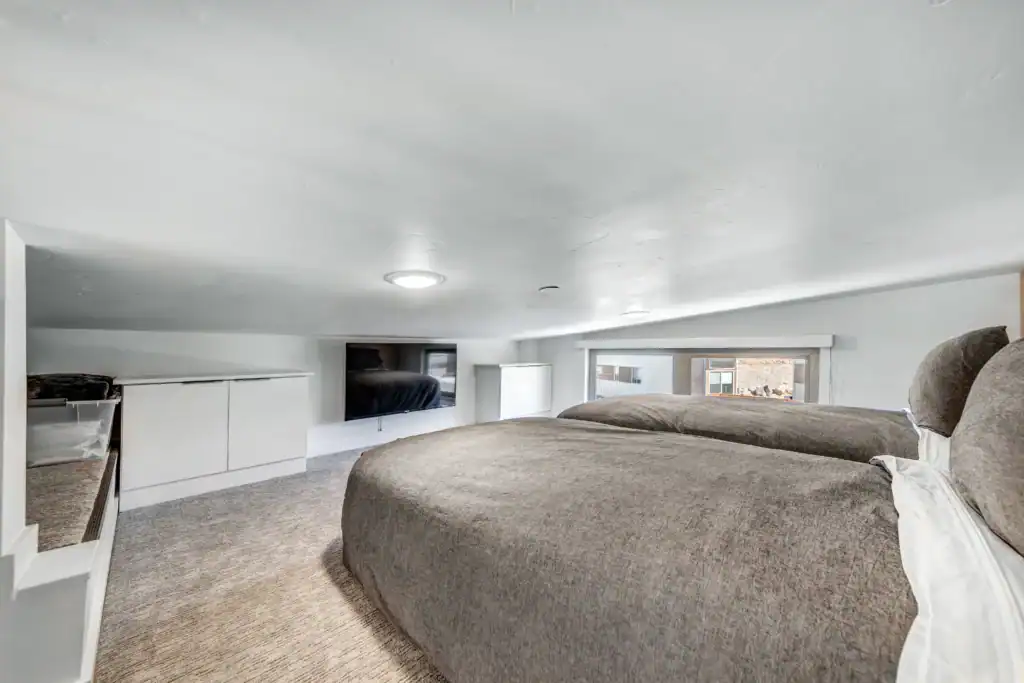 Interior view of a modern modular home bedroom with a low ceiling and minimalist design.