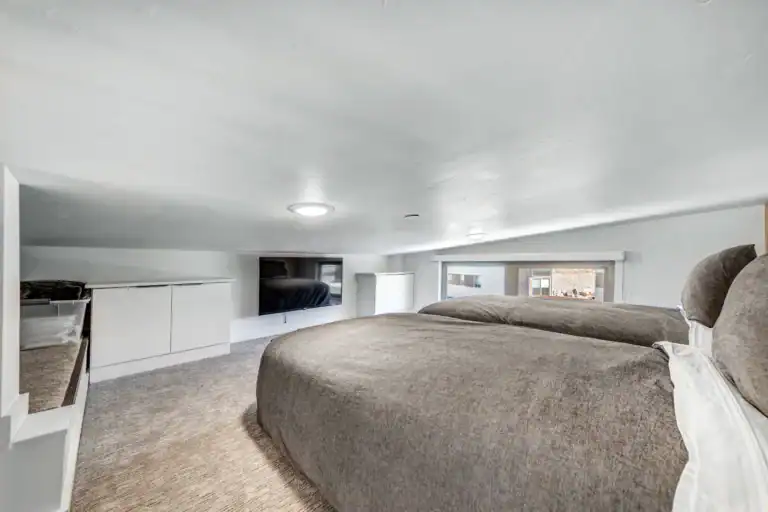 Interior view of a modern modular home bedroom with a low ceiling and minimalist design.