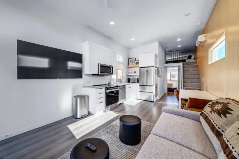 Open-concept modular home living room with kitchen and staircase.