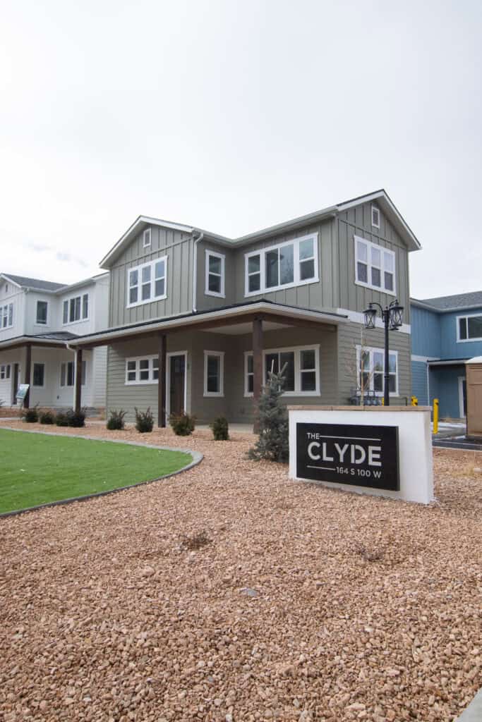 Clyde prefab home with large windows, covered porch, and modern design in a residential community.