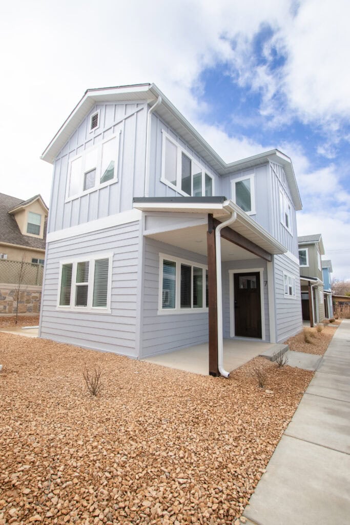 Contemporary Clyde Zip Kit Home with white siding and large windows.