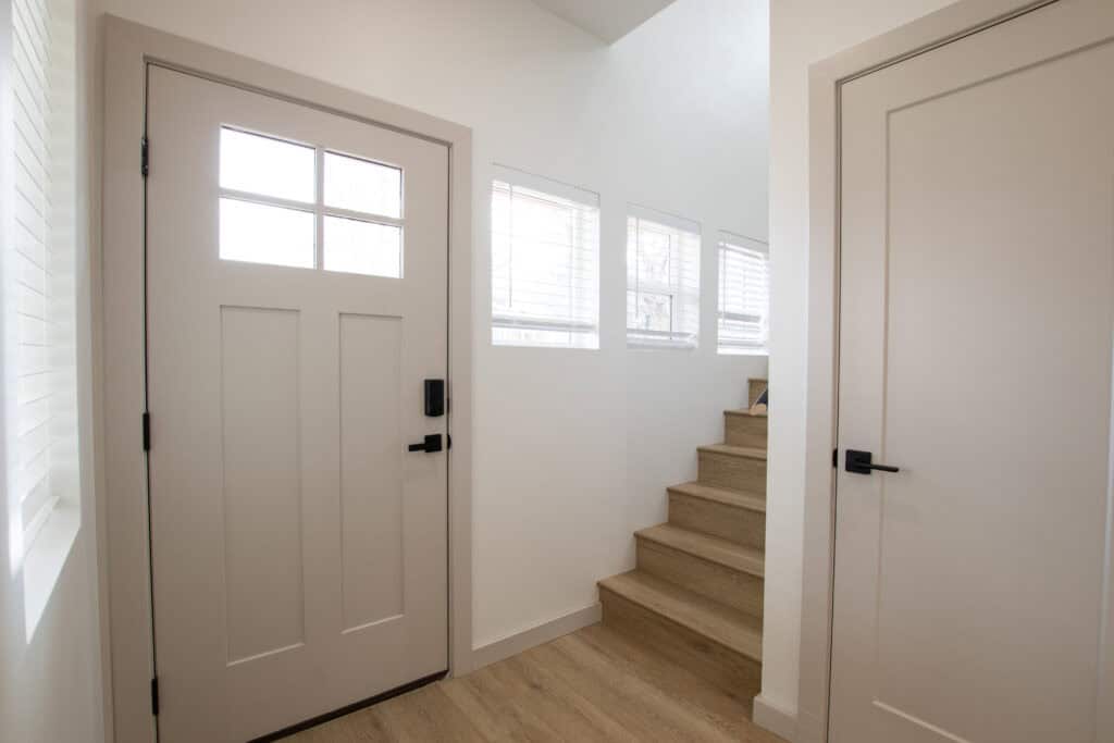 Modern interior entryway with staircase and white doors.