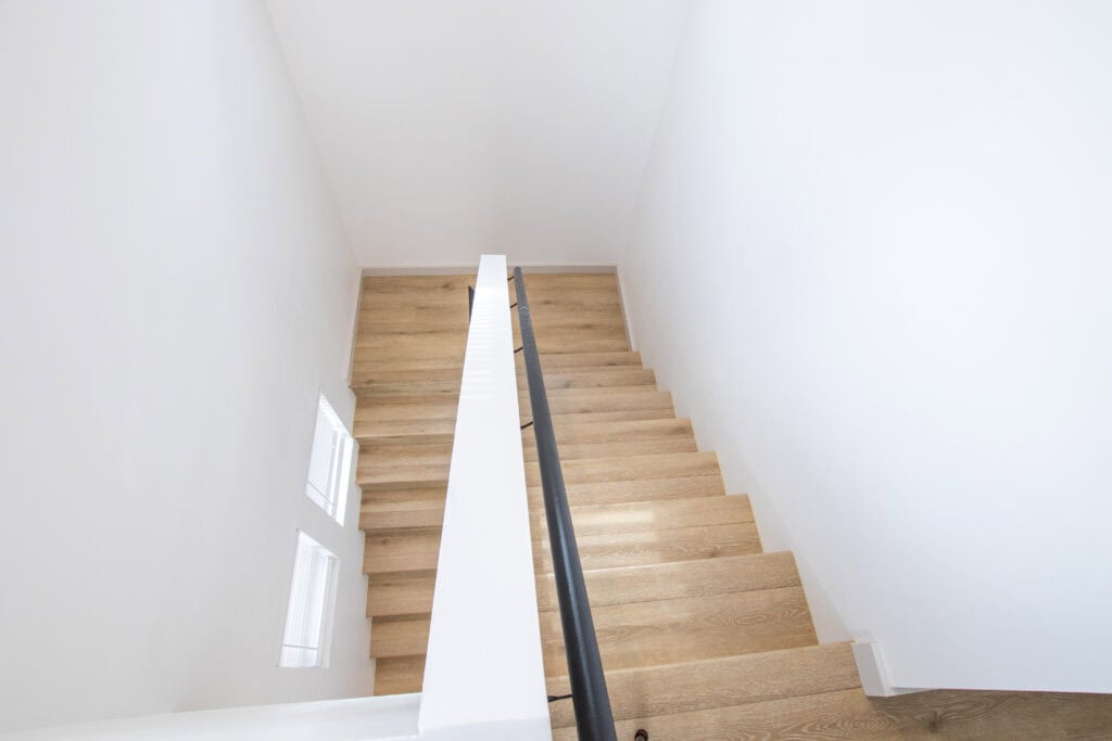 View of wooden staircase inside Clyde tiny home by Zip Kit Homes.