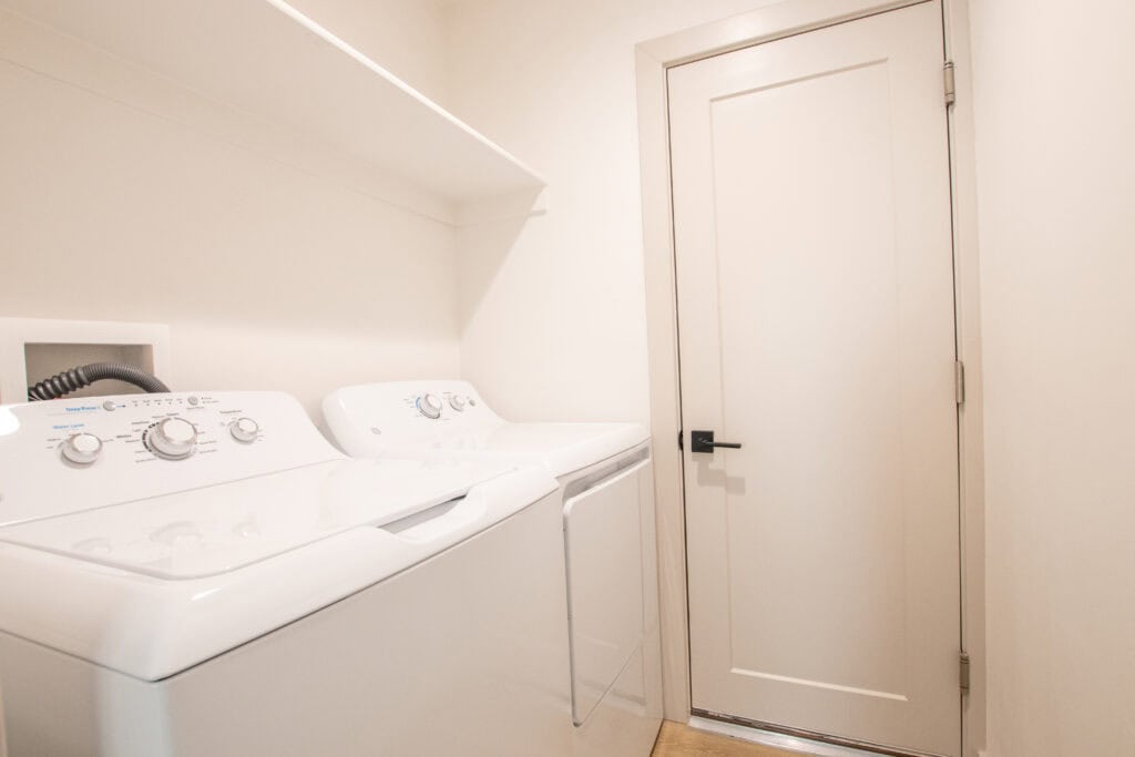 Laundry room with white washer and dryer in a compact space.