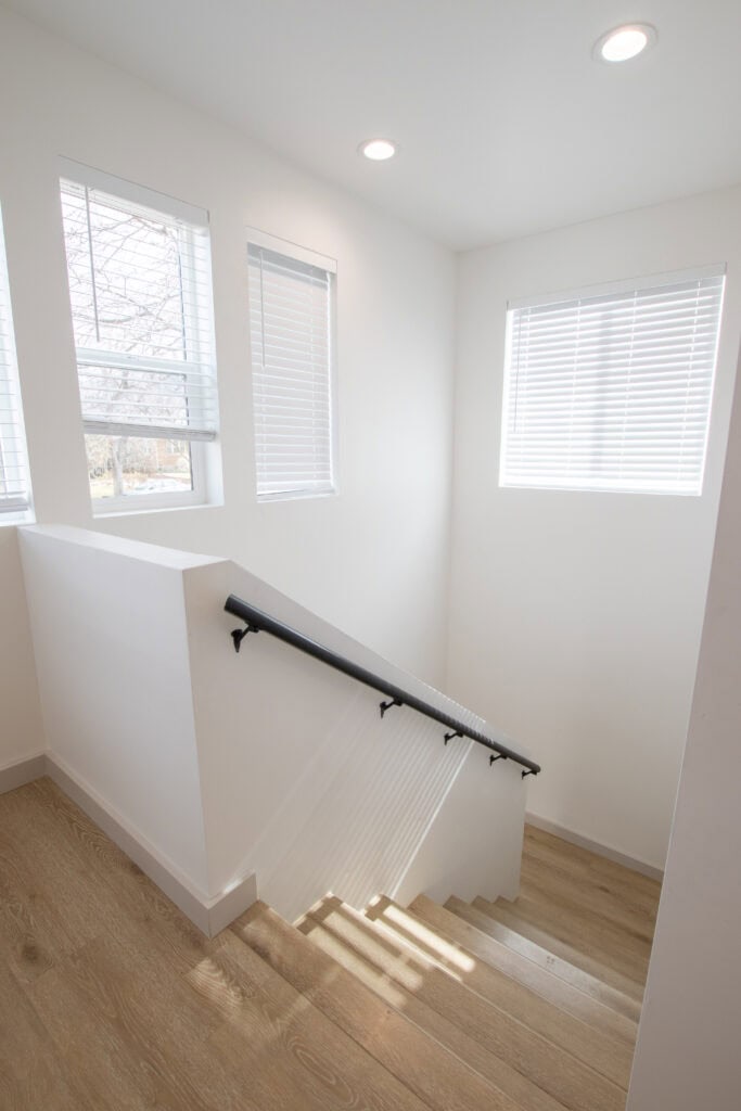 Zip Kit Homes interior staircase with natural light and white walls.