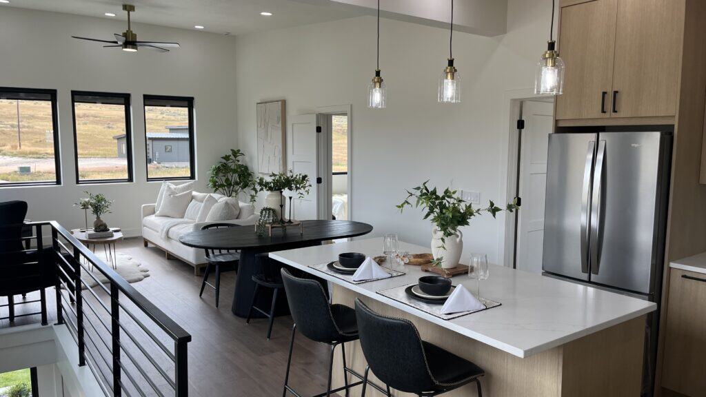 Bozeman home interior with open-concept kitchen, dining area, and living room featuring modern finishes and large windows.