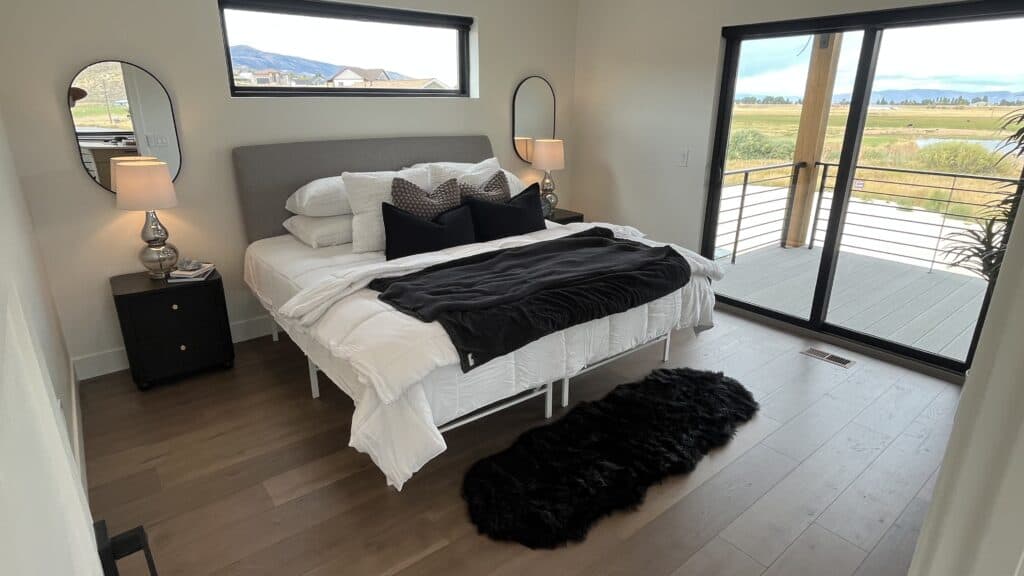Bozeman bedroom with modern furnishings, large sliding glass doors, and access to a private balcony.