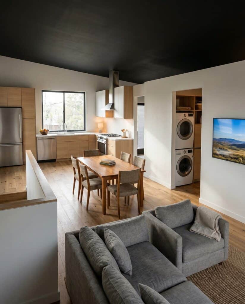 Koda home upstairs open-concept living area with kitchen, dining table, and modern finishes.
