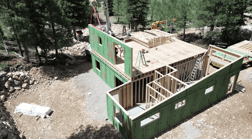 Zip Kit Homes Bozeman build showing wood framing, sheathing, and active construction crew