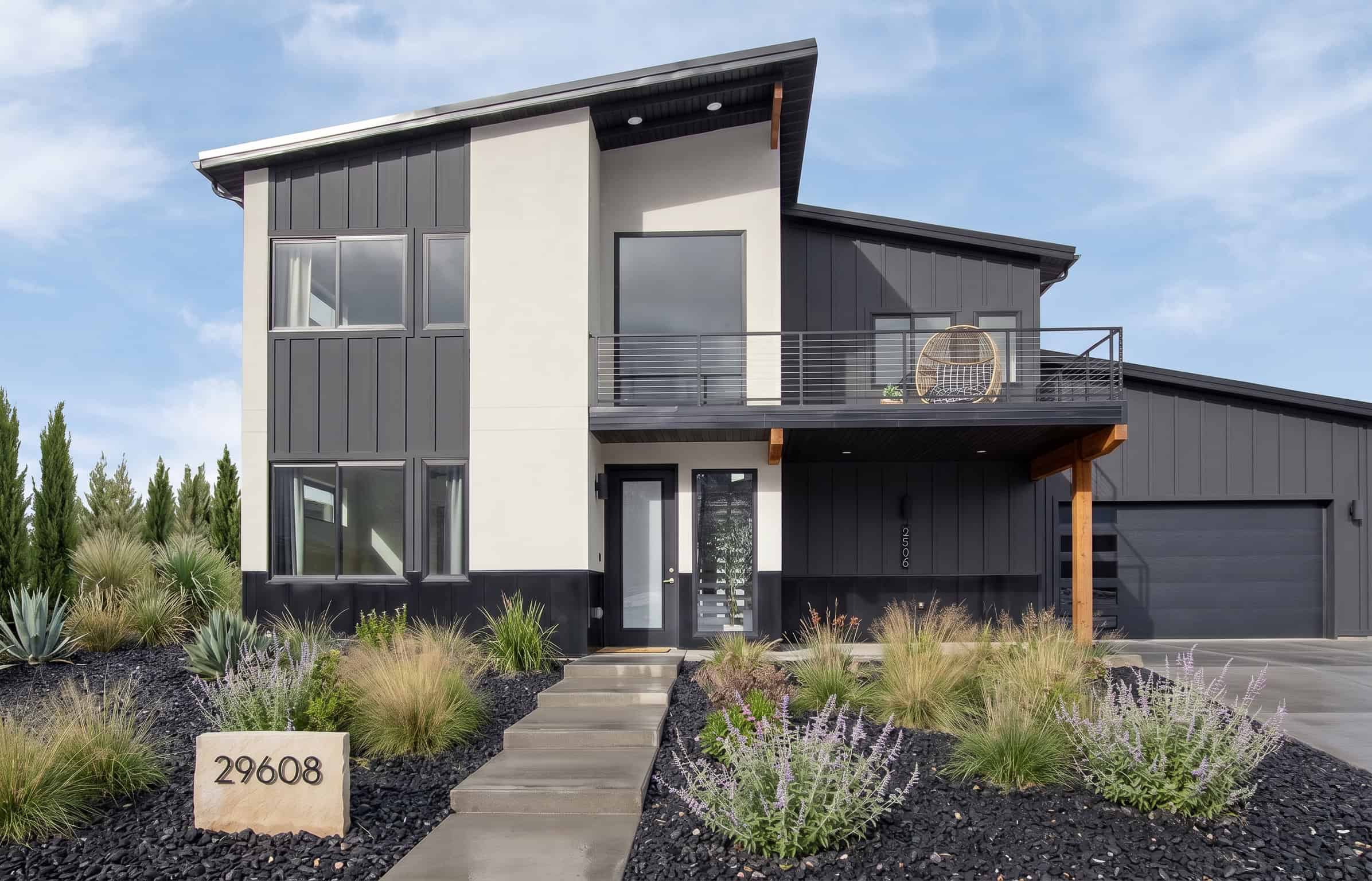 Solitude floor plan with black and white siding and wood accents.