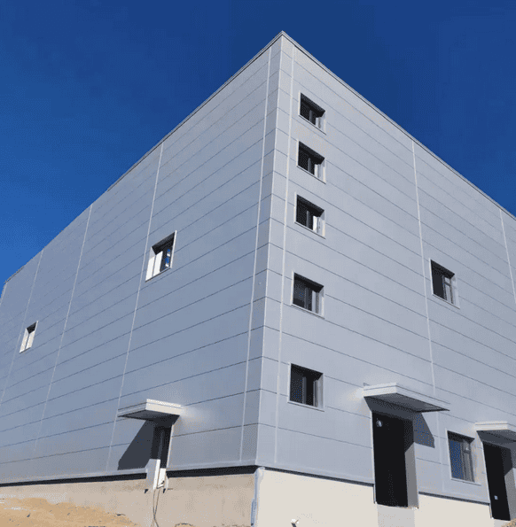 Modern Zip Kit Home exterior with sleek metal siding and multiple windows under a clear blue sky.