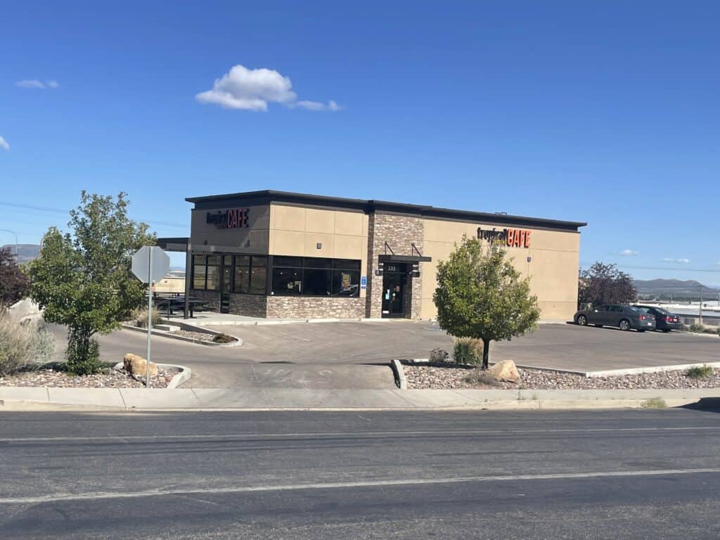 Zip Kit Homes storefront with stone and beige exterior, showcasing modern prefab building design.
