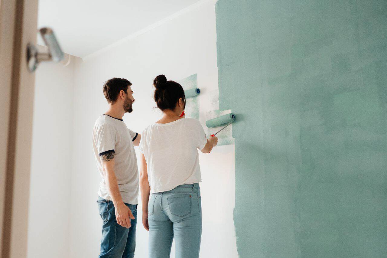 Couple painting a wall together