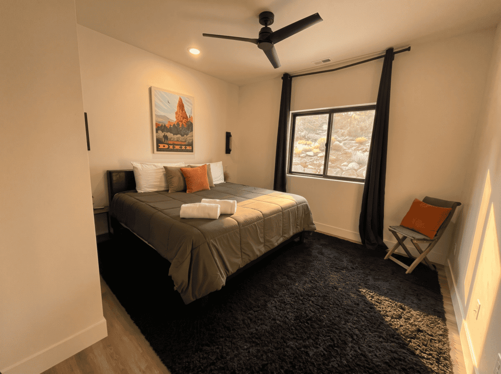 Interior of a modern Zip Kit home bedroom with a large window and minimalist decor.