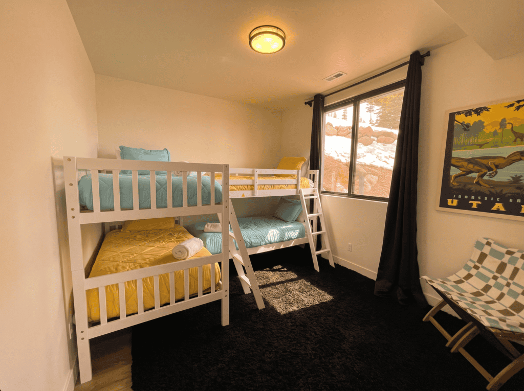 Cozy bedroom with bunk beds, window view, and colorful decor.
