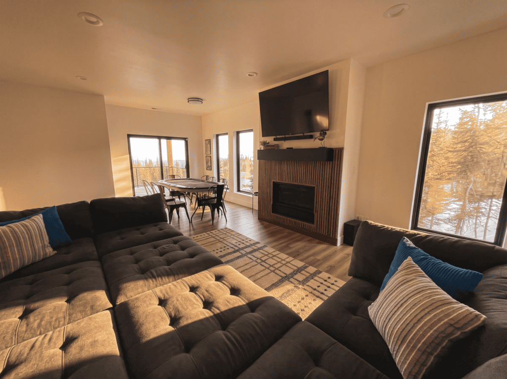 Spacious living room with large windows and cozy sectional sofa.