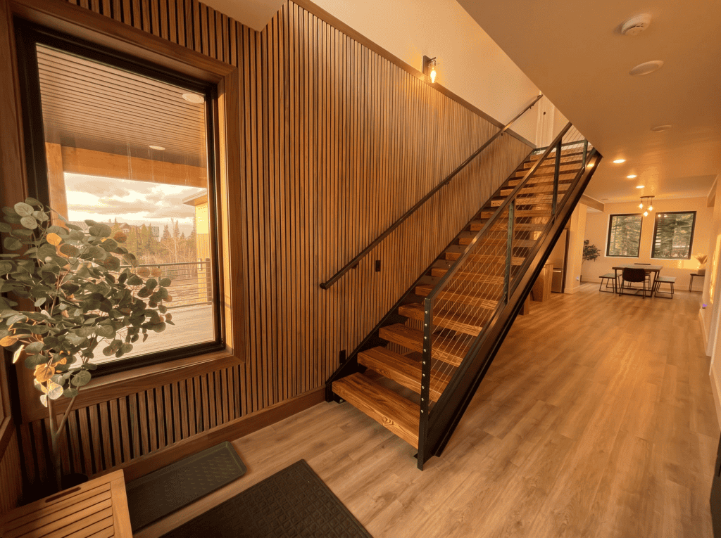 Interior staircase with wooden steps and black metal railing in Zip Kit Home.